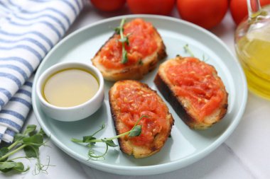 Domatesli lezzetli ekmek, mikro yeşiller ve beyaz masada yağ, yakın plan.