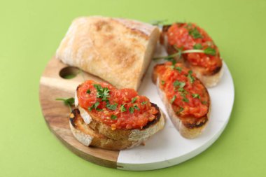 Domatesli lezzetli ekmek ve yeşil arka planda maydanoz, yakın plan.