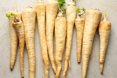 Bir sürü taze maydanoz kökü gri masada, düz yatıyordu.