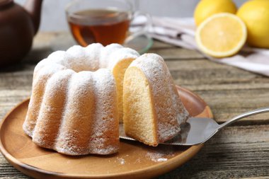 Tahta masaya pudra şekerli lezzetli limonlu pasta, yakın plan.