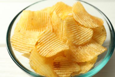 Lezzetli patates cipsleri beyaz masada, yakından.