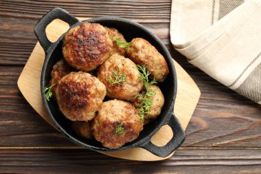 Lezzetli köfteler ve tavadaki dereotlar ahşap masada, üst tarafta.