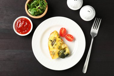 Siyah ahşap masada servis edilen lezzetli sebze güveci.