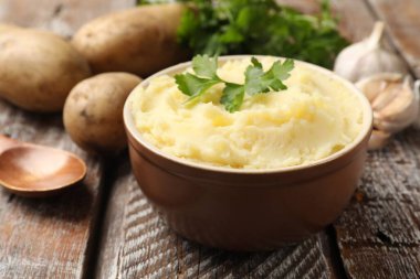 Maydanozlu patates püresi, ahşap masada sarımsak ve kaşık, yakın plan.