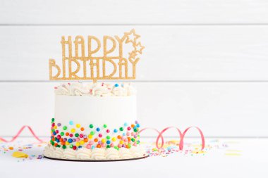 Lezzetli bento keki, üzerine renkli süslemeler, süslemeler ve beyaz masa üzerinde serpentin şeritler. Metin için boşluk