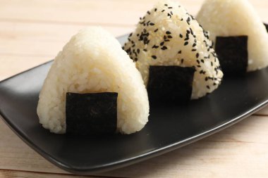 Pirinç topları (onigiri) ahşap masanın üzerinde, yakın plan. Geleneksel Japon yemeği