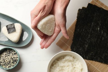 Beyaz masada nefis onigiri (Japon pirinç topları) yapan kadın.
