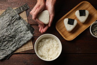 Ahşap masada nefis onigiri (Japon pirinç topları) yapan kadın.