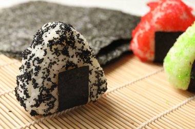 Lezzetli tobiko onigiri (Japon pirinç topları) masada servis edilir, yakın plan.