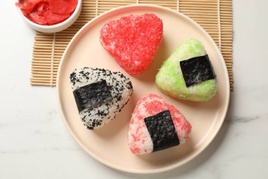Lezzetli tobiko onigiri (Japon pirinç topları) beyaz masada servis edilir.