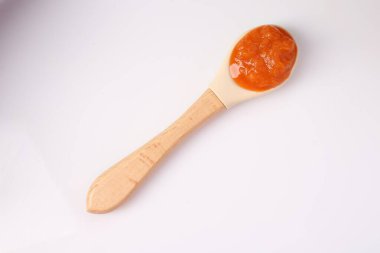 Bebek maması. Kaşıkla yapılan lezzetli püre beyaza izole edilmiş, üst manzara