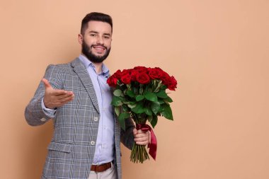 Bej arka planda kırmızı gül buketi olan mutlu adam, metin için boşluk.