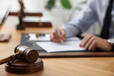 Ofisteki ahşap masada noter imzalı belge, hakimin tokmağına odaklan