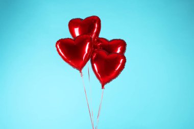 Açık mavi arka planda bir sürü kırmızı kalp şeklinde balon. Sevgililer Günün kutlu olsun.