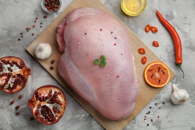 Çiğ hindi göğsü ve salamura için malzemeler gri desenli masada, düz yerde.