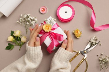 Çiçek kutusu, çiçek, makas ve bej arka planda kurdele olan bir çiçekçi.