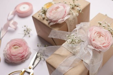 Çiçekçi. Beyaz arkaplanda kutular, çiçekler, kurdele ve makas, yakın plan