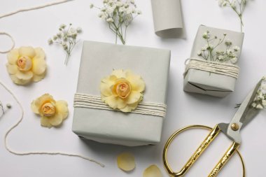 Çiçekçi. Beyaz zemin üzerinde kutular, çiçekler ve makas, düz yatıyordu