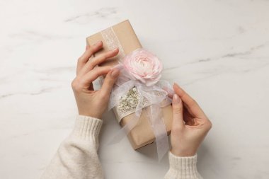 Beyaz arka planda hediye kutusu olan bir çiçekçi.