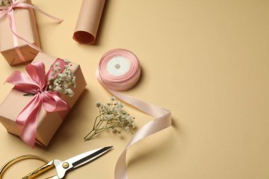 Çiçekçi. Bej arkaplanda kutular, çiçekler, kurdele ve makas, metin için boşluk