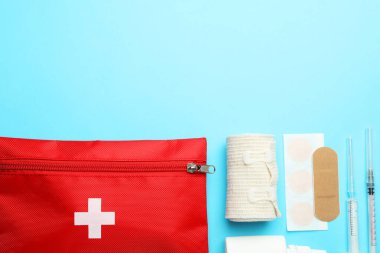 Açık mavi arkaplan üzerine ilk yardım çantasıyla düz konum, metin için boşluk