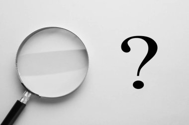 Soru işareti ve büyüteç açık arkaplanda, üst görünümde
