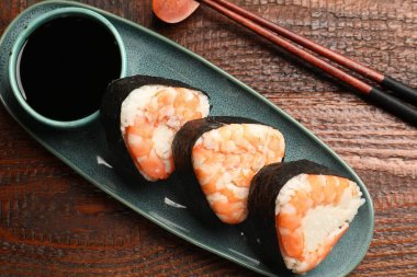 Lezzetli onigiri (Japon pirinç topları) karidesler ahşap masada servis edilir, düz yatar.