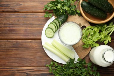 Sağlıklı maydanoz içeceği, yapraklar, kereviz ve salatalık ahşap masada, düz yerde. Metin için boşluk