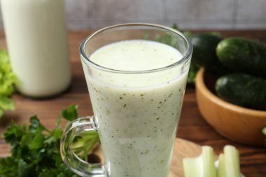 Sağlıklı maydanoz içeceği, yapraklar, kereviz ve salatalık ahşap masada, yakın plan.