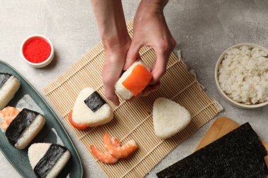 Onigiri yapan kadın (Japon pirinç topları) ışık masasında, üst manzara