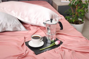 Yatakta nefis kahve ve lale ve ipek çarşaflar.