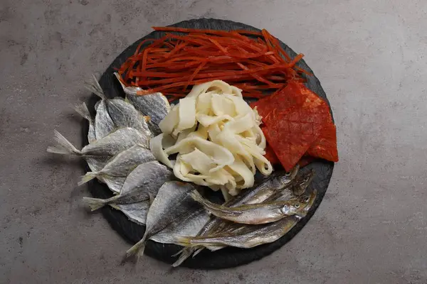 Gri masada birçok farklı kurutulmuş balık aperatifleri var.