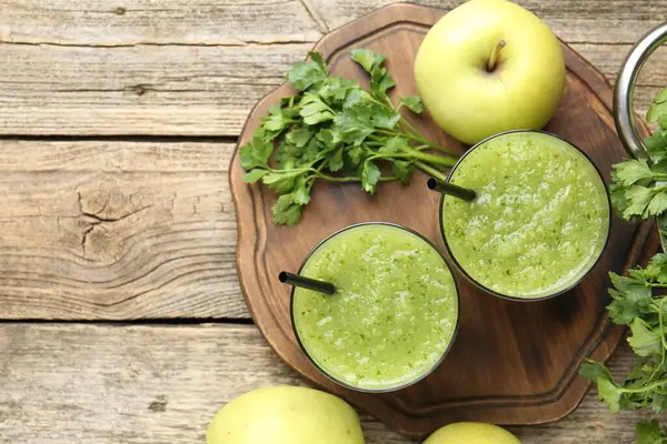 Sağlıklı maydanozlu buzlu içecek, tahta masada yapraklar ve elmalar, düz uzanma. Metin için boşluk