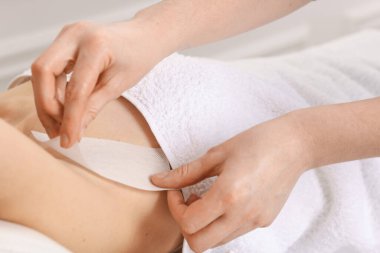 Güzellik salonunda balmumu epilasyon uygulanan kadın, yakın plan.