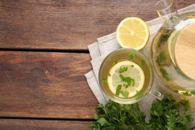 Tahta masa üzerinde limon dilimleri olan sağlıklı maydanoz çayı, düz yatak ve yazı için yer. Detoks içeceği