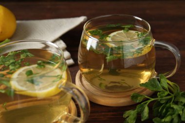 Tahta masada limon dilimleri olan sağlıklı maydanoz çayı, yakın plan. Detoks içeceği