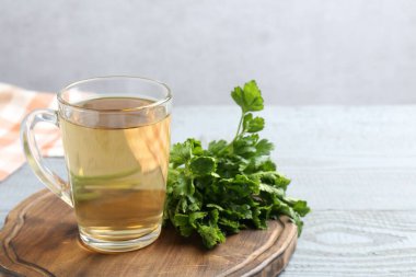 Sağlıklı maydanoz çayı gri ahşap masada, yazı için yer var. Detoks içeceği