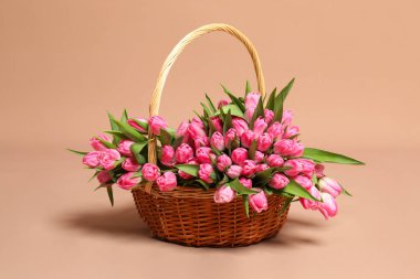 Hasır sepette bej arka planda güzel laleler.