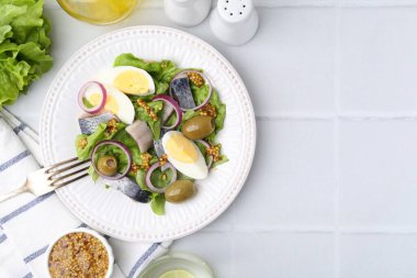 Ringa balıklı, yumurtalı, hardallı ve sebzeli nefis salata. Beyaz fayanslı masa, düz yatak. Metin için boşluk