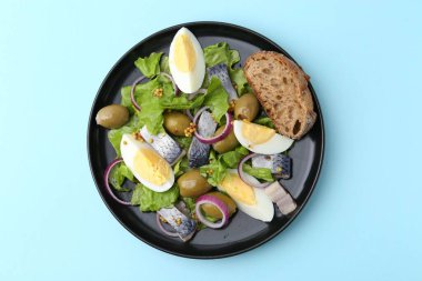 Ringa balıklı lezzetli salata, yumurta, hardal ve sebzeler açık mavi arka planda, üst manzara