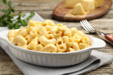 Peynir soslu lezzetli makarna, maydanoz ve ahşap masa çatalı, yakın plan.