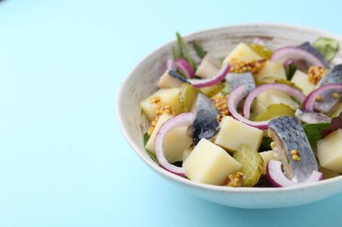 Ringa balıklı lezzetli salata, sebze ve açık mavi arka planda hardal, yakın plan. Metin için boşluk