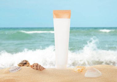 Güneş kremi ve deniz kenarındaki kumsalda bulunan deniz kabukları.