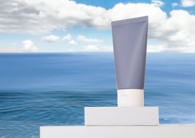 Deniz kenarında güneş kremi tüpü. Podyumlu şık bir sunum