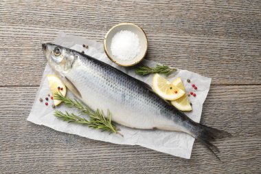 Tuzlu ringa balığı ve baharatlar ahşap masada, düz yatıyordu.
