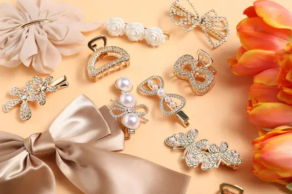 Güzel saç tokaları, bej arka planda fiyonk ve laleler.