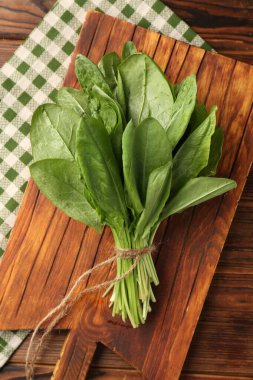 Tahta masanın üstünde taze yeşil kuş yaprakları var.