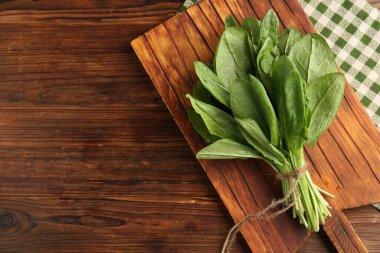 Ahşap masanın üstünde taze yeşil kuş yaprakları var. Metin için boşluk