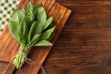 Ahşap masanın üstünde taze yeşil kuş yaprakları var. Metin için boşluk