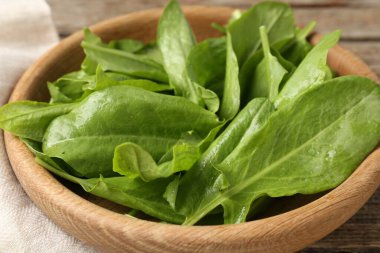 Taze yeşil kuş yaprakları kasede, masada, yakın plan.